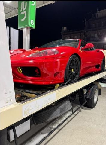 積載車に載せて搬送中の赤いスポーツカー